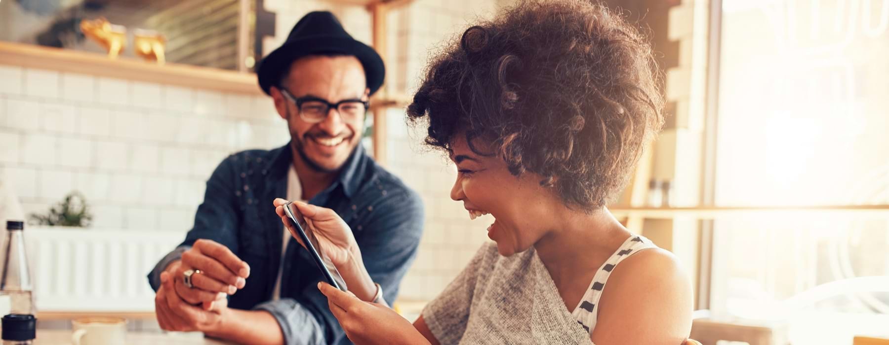 man and woman laughing at a phone